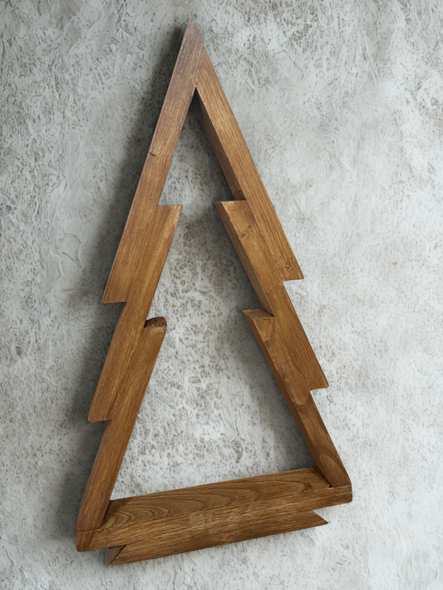 Our handmade XL Christmas tree decoration made from solid chestnut wood pictures hanging on a wall.