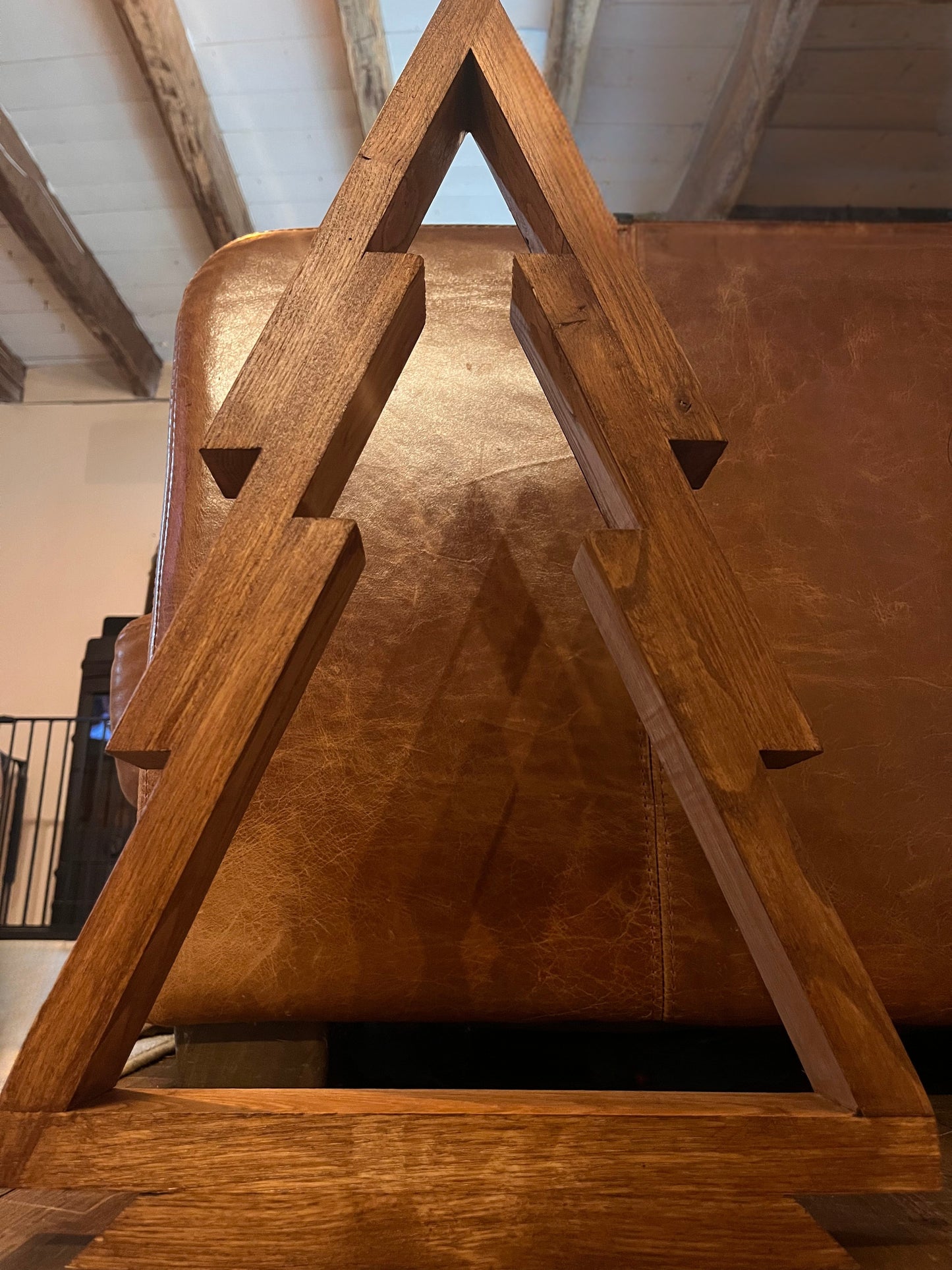 Handmade artisanal christmas decoration featured in a rustic Charentaise house with brown leather sofas, black wood burner and oak beams.