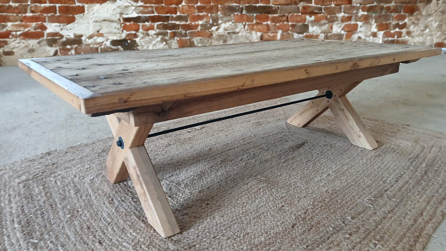 Rustic industrial oak coffee table “Lisonne” made from reclaimed French oak, shown against a red brick wall background with visible steel threadbar detail painted black.