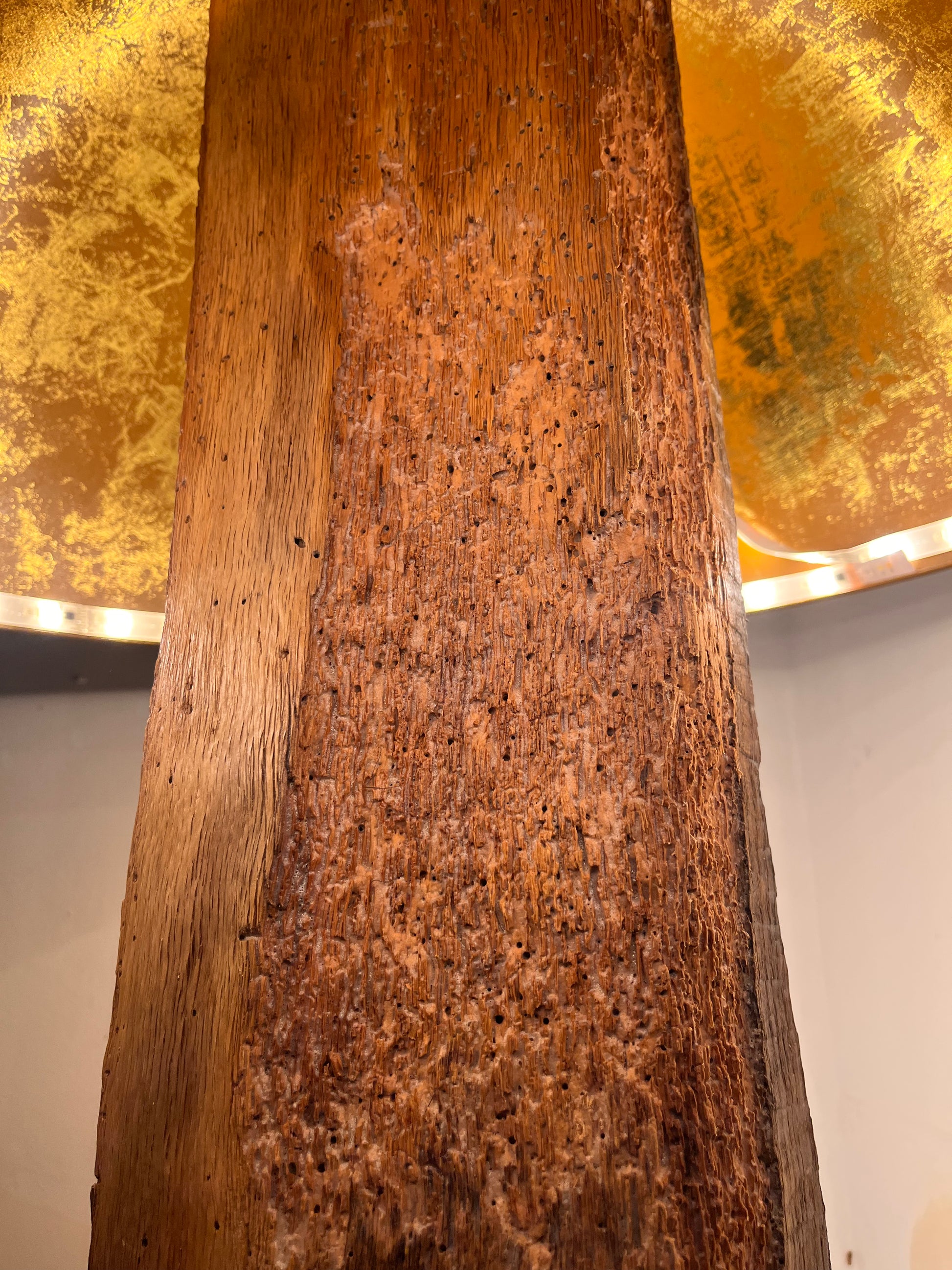 Close-up of the solid oak floor lamp showing the natural grain, markings from ageing, and the clear coat varnished finish highlighting the wood’s texture and character.